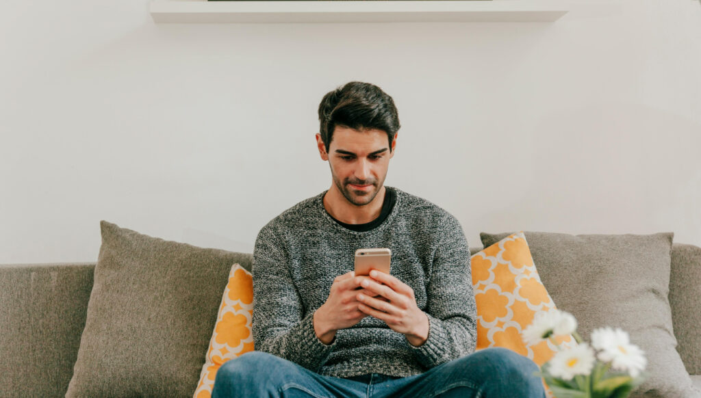 Homem concentrado usando celular.