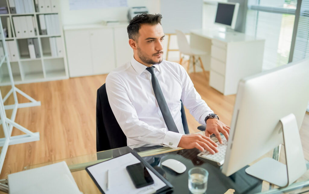 Homem de social trabalhando em seu computador.