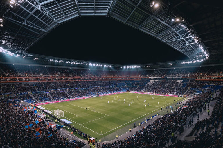 Partida de futebol acontecendo em um estádio lotado.