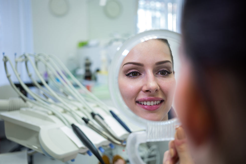 paciente no consultório odontológico olhando o sorriso em um espelho