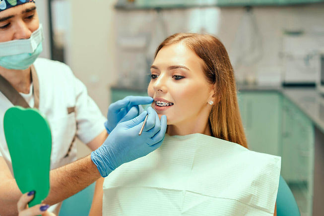 ortodontista mostrando o resultado do tratamento para a paciente