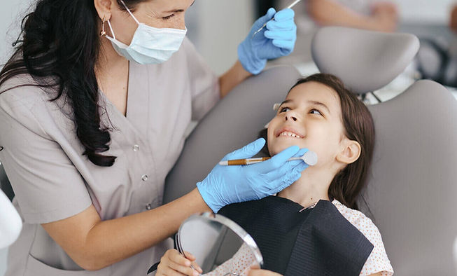 menina realizando uma avaliação dos dentes com sua ortodontista