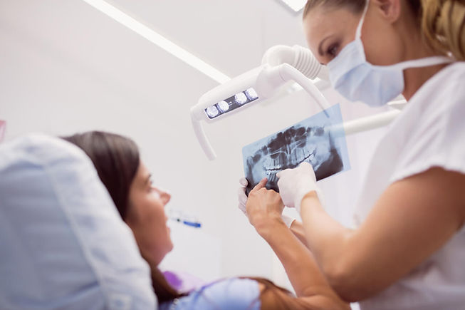 dentista mostrando o raio-x de diagnóstico ao paciente
