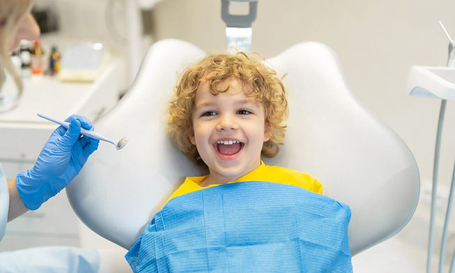 menino tendo seus dentes verificados pelo odontopediatra no consultório odontológico