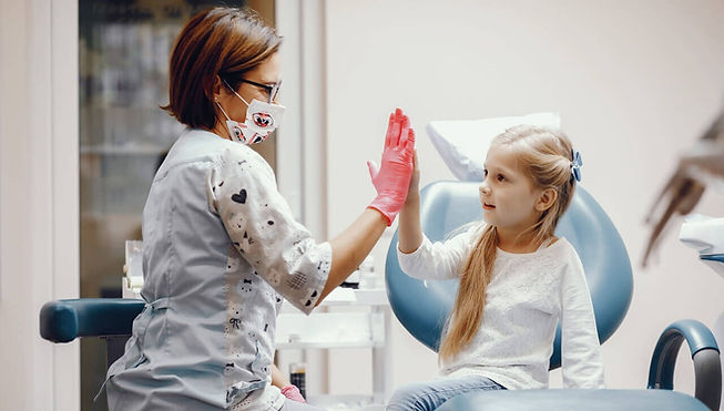 odontopediatra atendendo menina em seu consultório odontológico